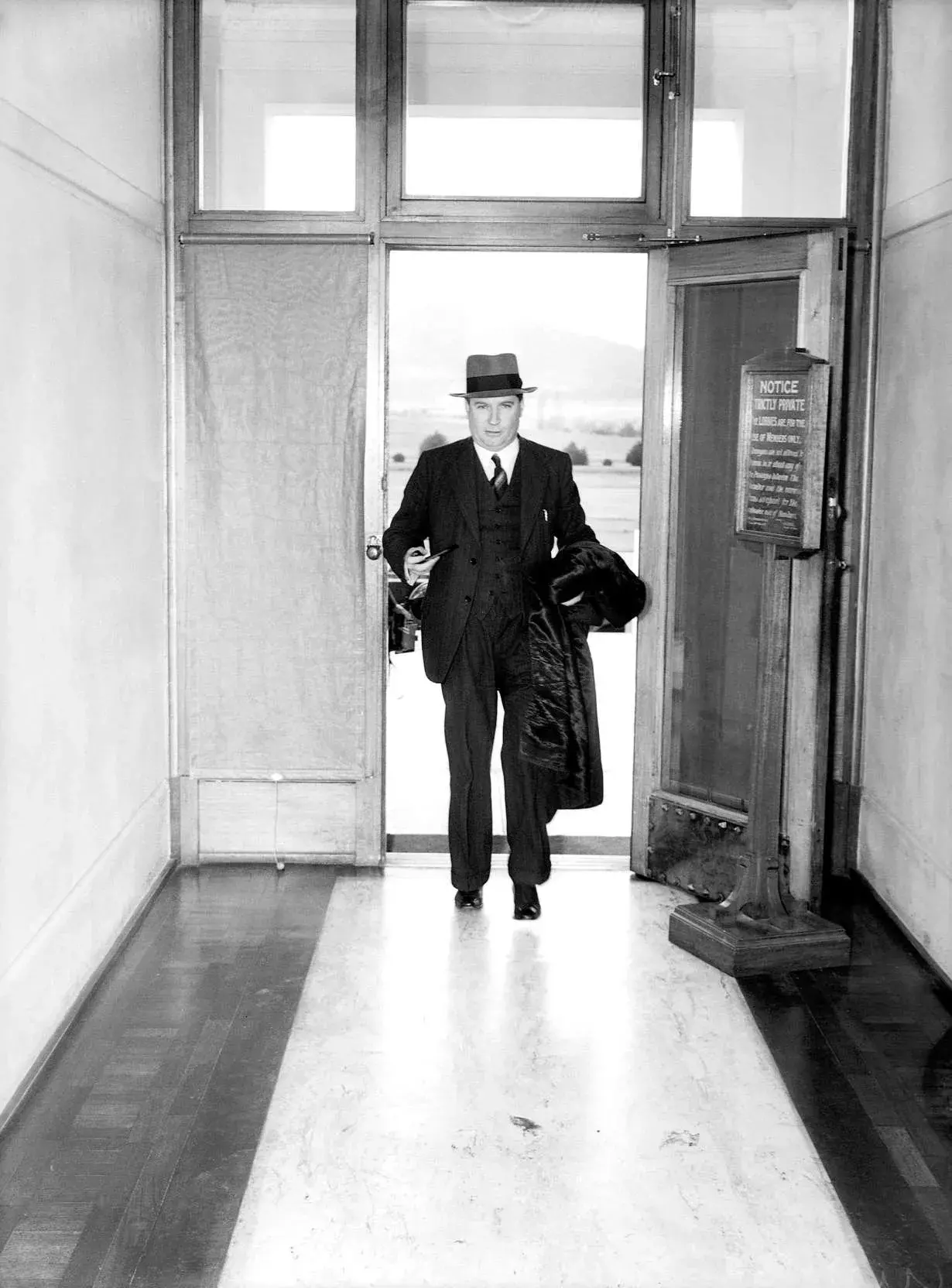 Arthur Fadden walking through the door to Old Parliament House.  