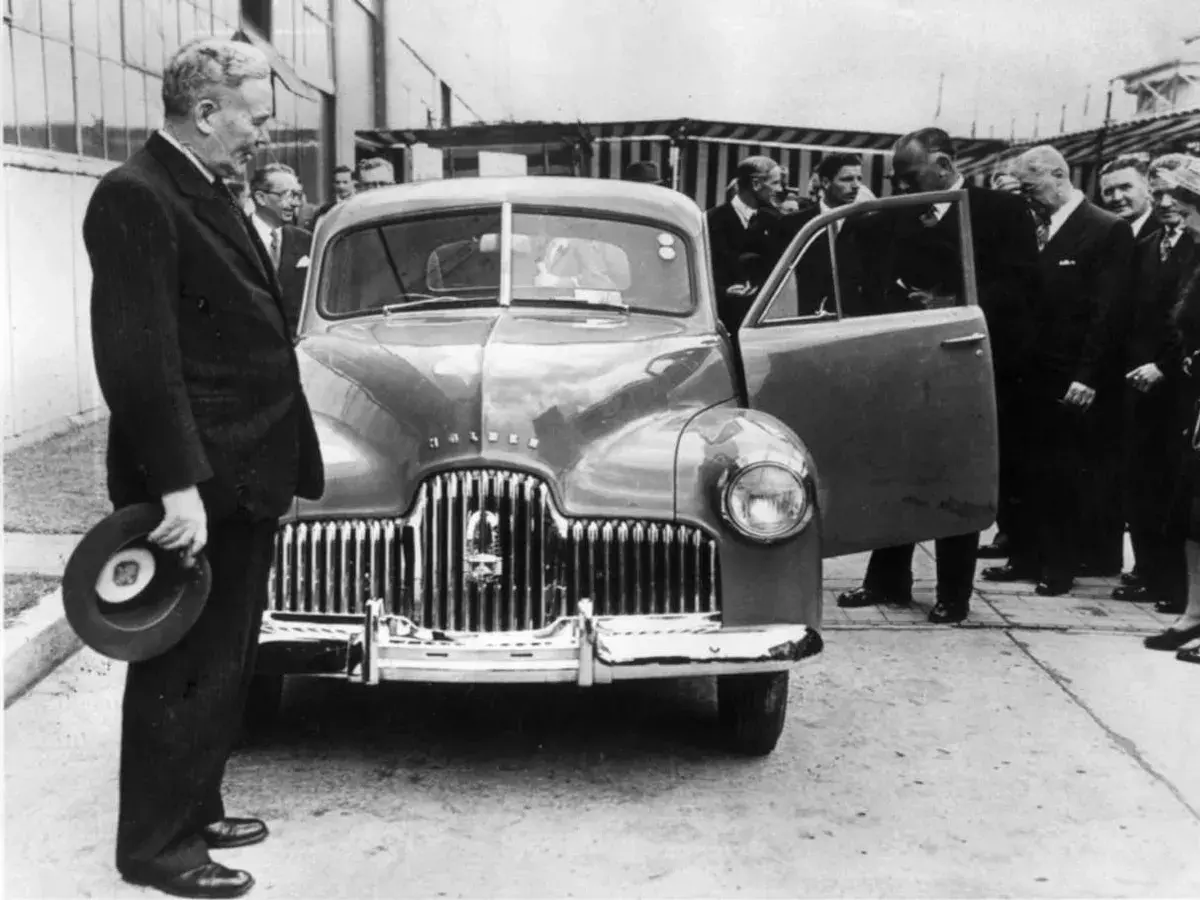 Ben Chifley standing in front of a new car surrounded by people. 