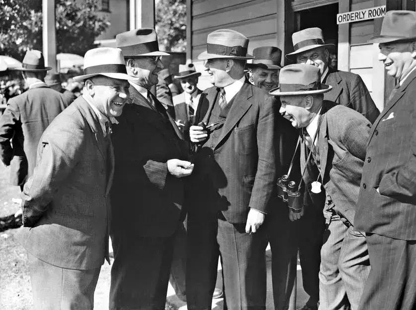 Arthur Fadden standing in a group of men laughing. 