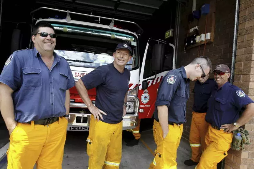 Tony Abbot at a fire station dressed in fire clothes.  