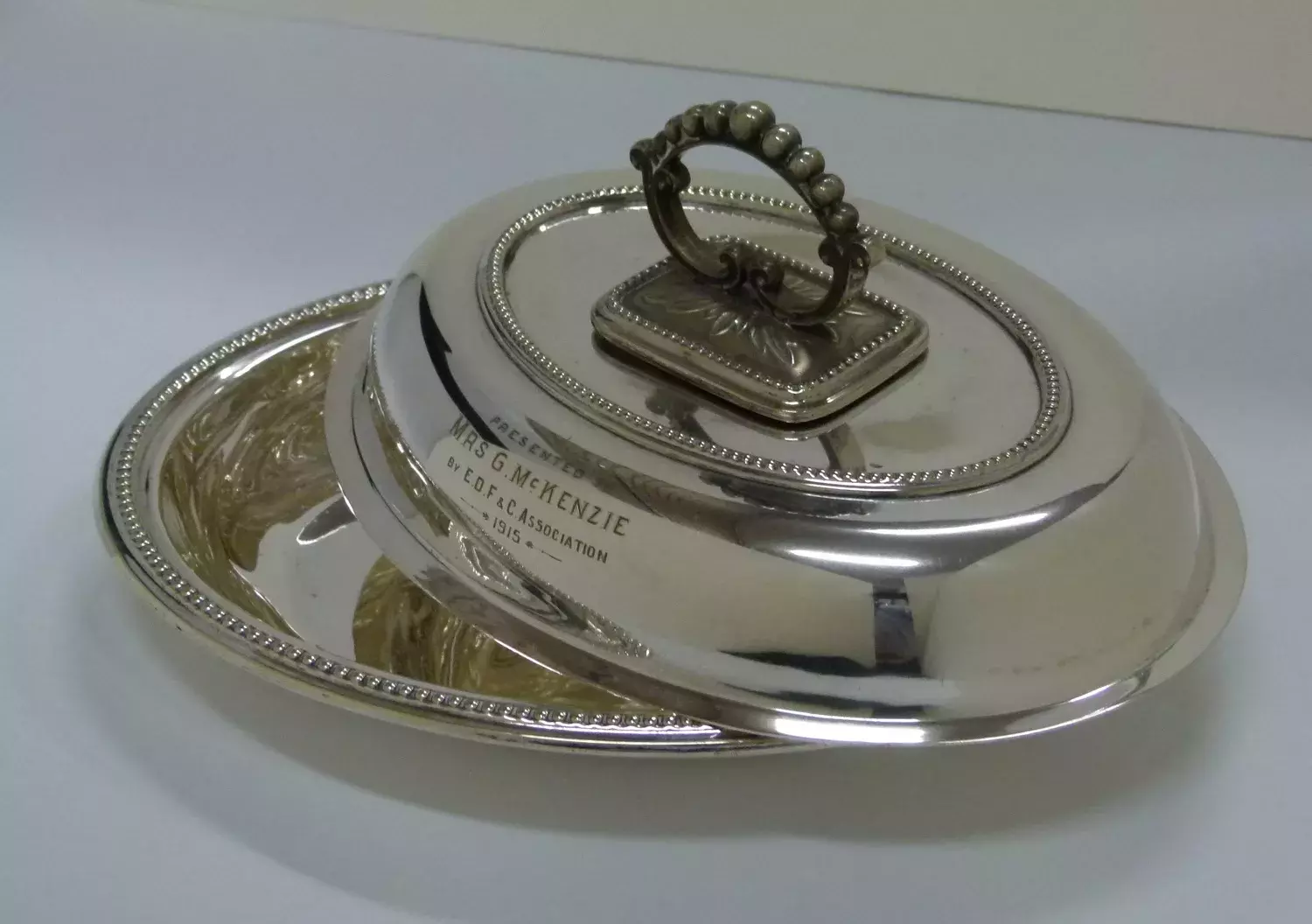 A silver cooking dish with an engraving.  