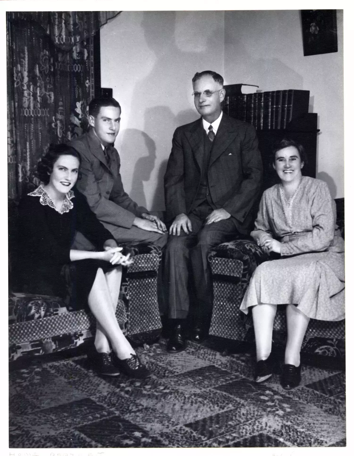 John Curtin and his wife and two children pose for a photo in a living room.  