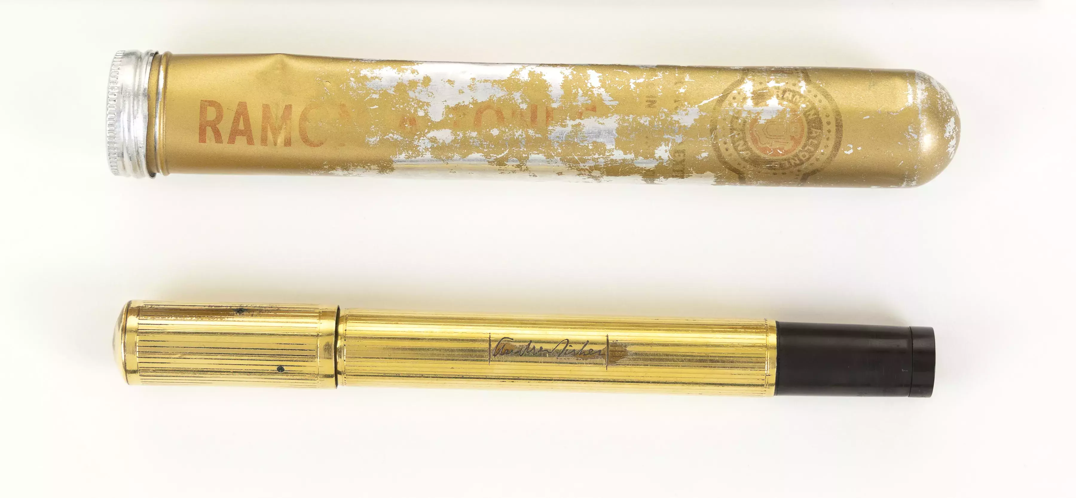 A gold fountain pen with a black base and a battered gold cigar case.  